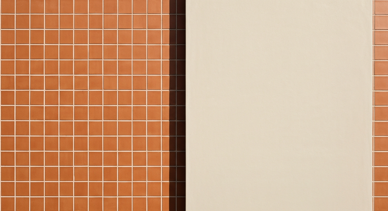 Two surfaces side by side - warm terracotta tile and smooth pale ceramic, equal light, architectural detail, no faces
