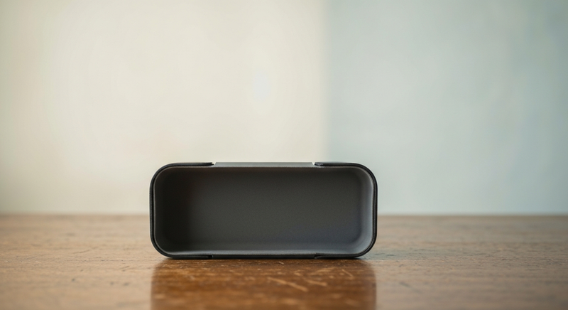 Small round clear case on folded linen fabric in warm afternoon light, editorial still life photography, minimal warm palette