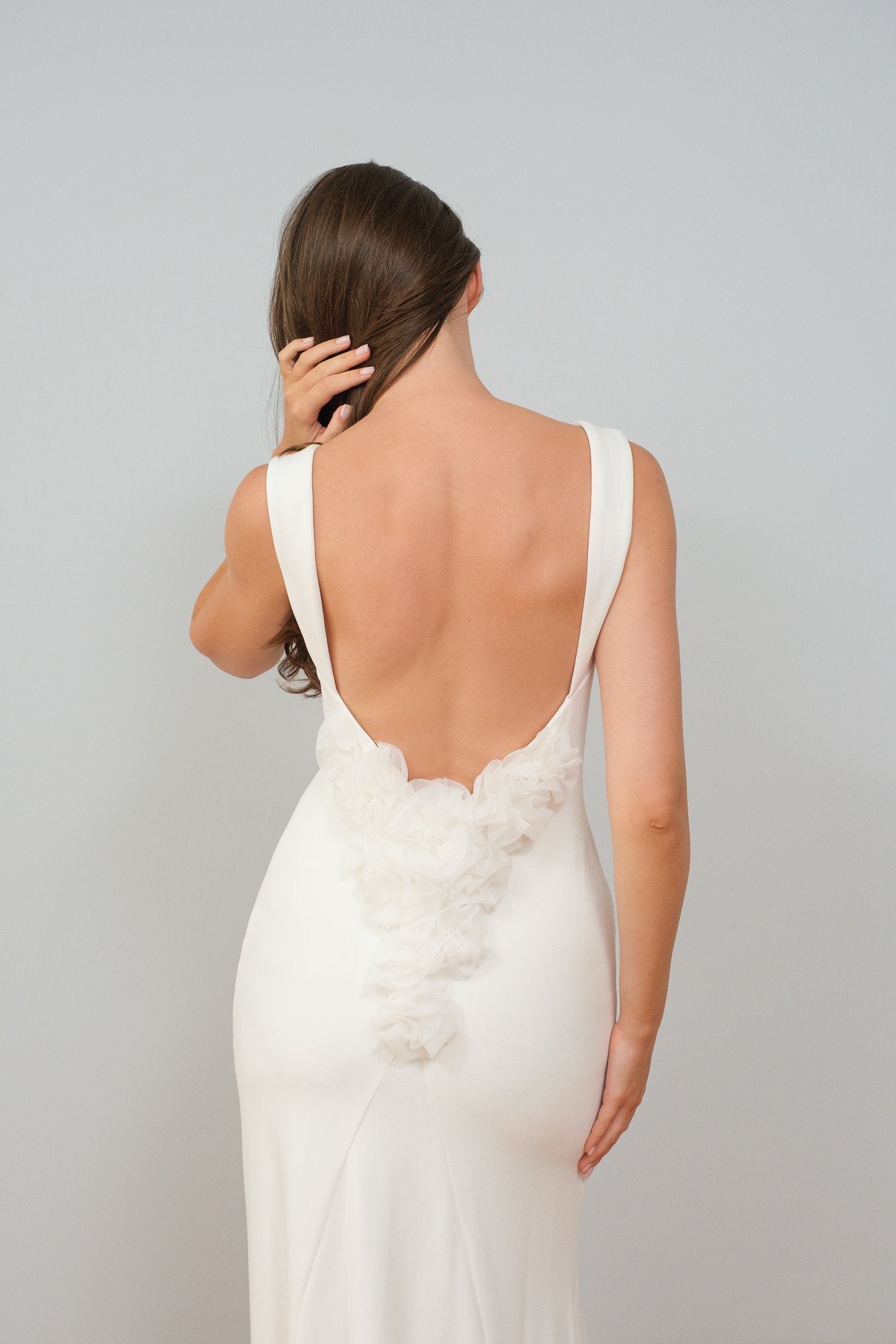 Woman wearing open-back white dress with invisible silicone covers by Skindelle