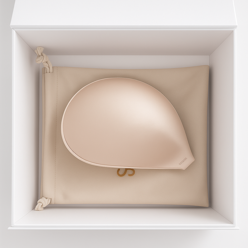 Beige handbag with gold accents in a white box with Skindelle adhesive bra inside